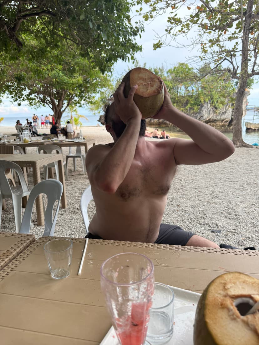 Dan drinking coconut at beach